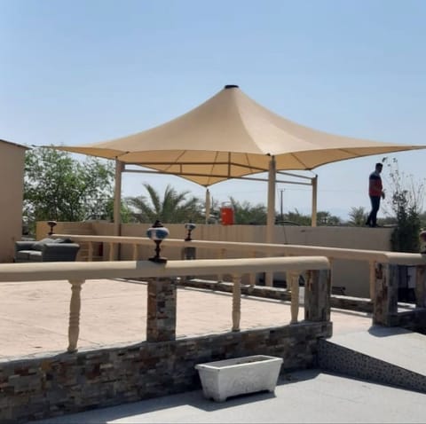 Sand-coloured conical shade over a terrace with stone balustrade