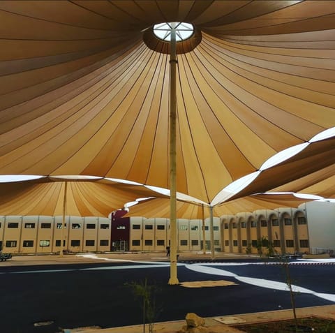 Conical tensile canopies with a crown ring in a school courtyard