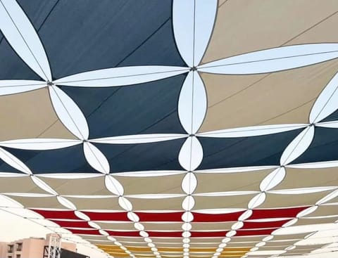 Underside of a patterned shade sail grid in navy, sand and red