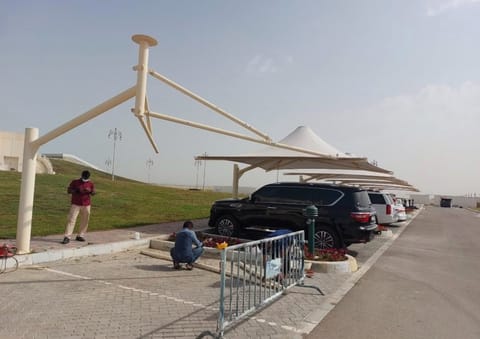Cantilever car park shade frame being installed over a row of parked cars