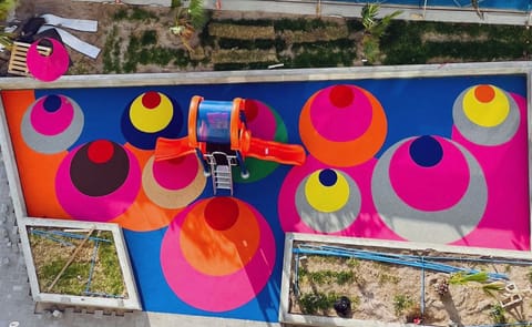Aerial view of play flooring with bright pink, orange and blue circles